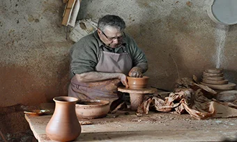 artisan fabrique des pots en terre cuite